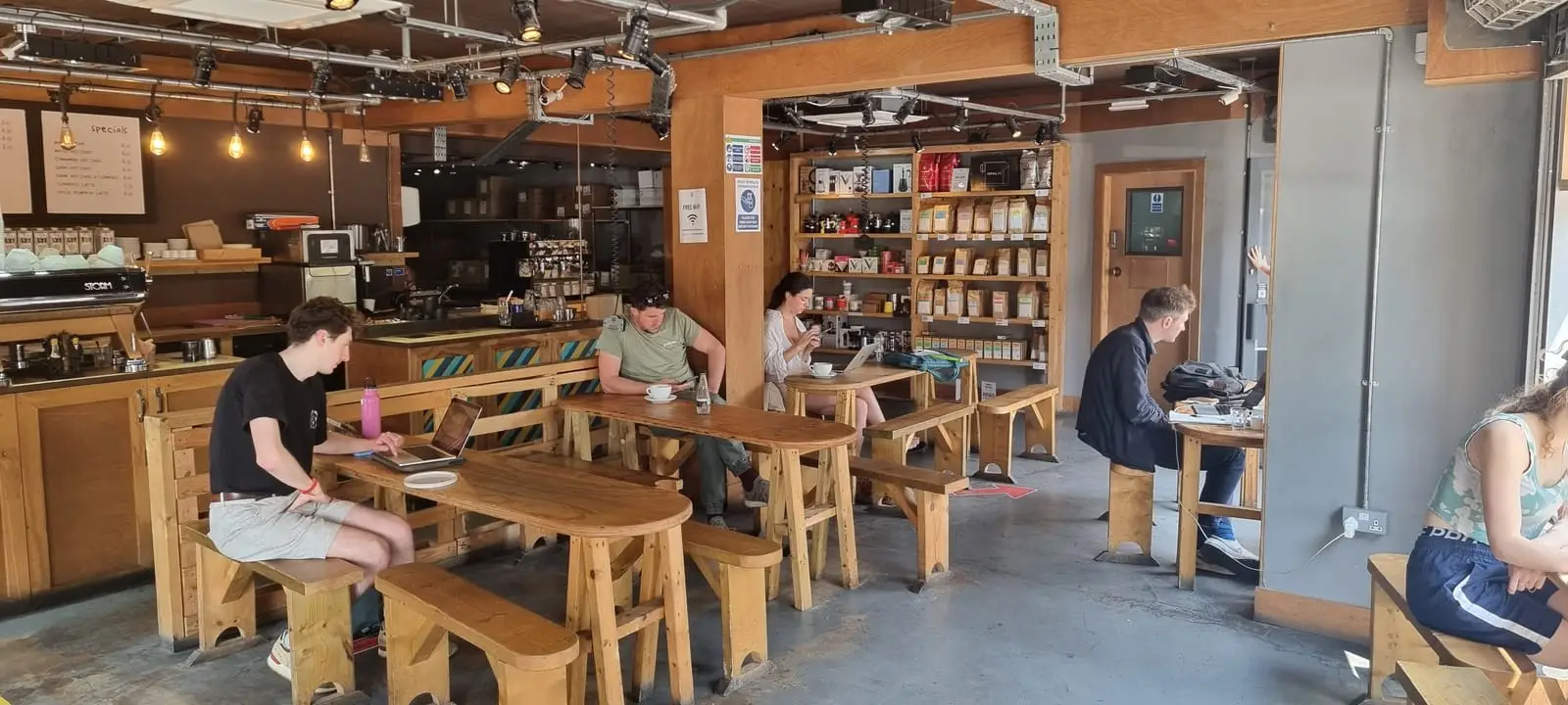 The warehouse interior at Doppio, with people working at wooden benches